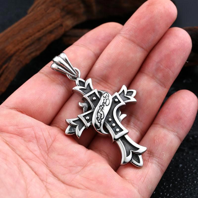 a hand holding a gothic cross